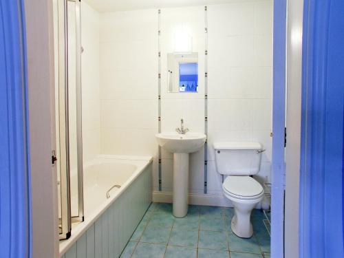 a white bathroom with a toilet and a sink at Bank End in Glenridding