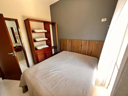 Dormitorio pequeño con cama y espejo en Villagio Valentina, en São Sebastião