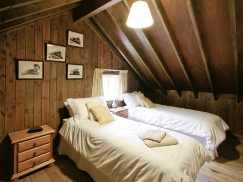 two beds in a room with wooden walls at The Station - E5336 in Wetheringsett