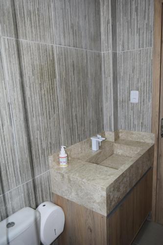 uma casa de banho com um lavatório em mármore e um WC. em Hospedagens São Borja RS em São Borja