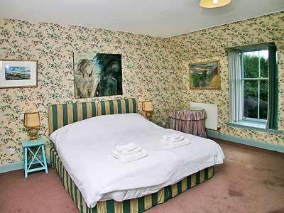 a bedroom with a bed in a room with wallpaper at Marwhin House - Swwr in Kirkpatrick Durham