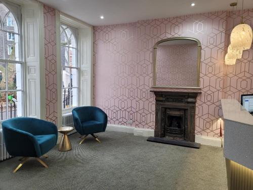 ロンドンにあるジョージ ホテル - B&Bのリビングルーム(椅子2脚、暖炉付)