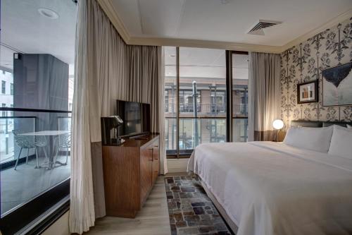 a hotel room with a bed and a large window at Hotel Indigo New Orleans - French Quarter in New Orleans