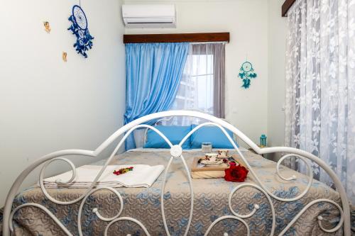 1 cama blanca en un dormitorio con cortinas azules en Stratos Seaside corner apartment, en Rethymno
