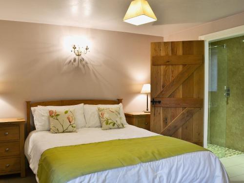 1 dormitorio con cama y puerta corredera de granero en Mere Croft en Sebergham