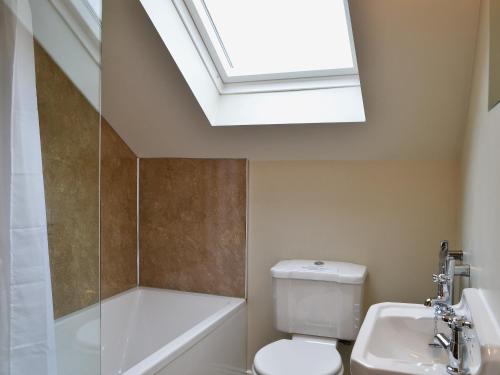 uma casa de banho com um WC, um lavatório e uma clarabóia em Mere Croft em Sebergham