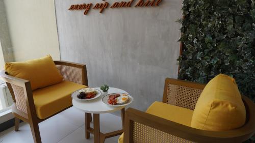 a room with a chair and a table with a plate of food at Hotel One in Cebu City