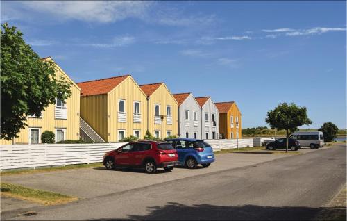 two cars parked in front of a row of houses at Apartment Skudehavnen in Rudkøbing