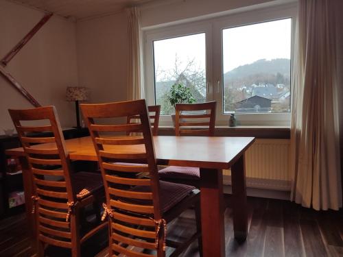 une table à manger avec des chaises et une fenêtre dans l'établissement Ferienwohnung Finkeldei, à Winterberg