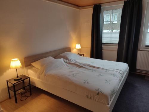 um quarto com uma cama, 2 candeeiros e uma janela em Ferienwohnung Finkeldei em Winterberg