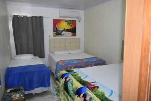 ein Schlafzimmer mit 2 Betten und einem Wandgemälde in der Unterkunft Hospedagens São Borja RS in São Borja