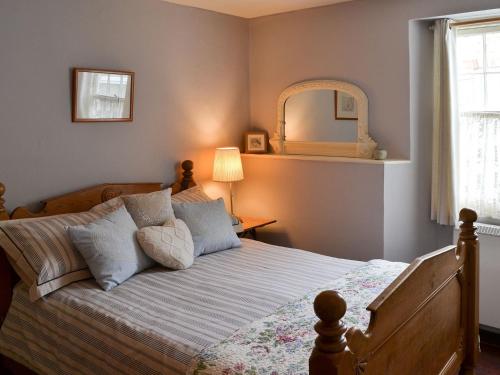 a bedroom with a bed with a mirror on the wall at Fairmaiden in Polruan