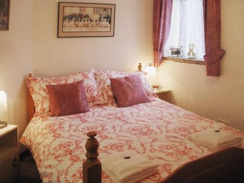 Thorpe MarketにあるPuddleduck Cottageのベッドルーム1室(花柄のベッドカバー付)