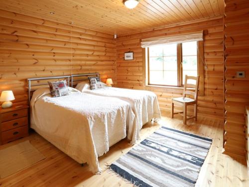 a bedroom with two beds in a log cabin at Kingfisher Lodge in Hagwothingham