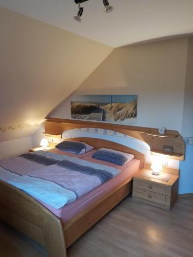 1 dormitorio con 1 cama grande de madera y 2 almohadas en FeWo oben, en Kalletal