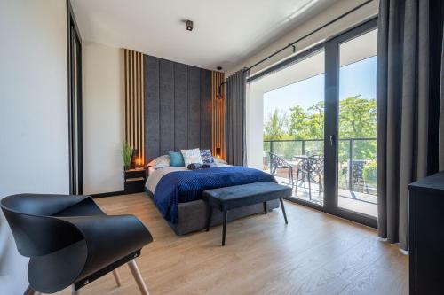 sypialnia z łóżkiem i dużym oknem w obiekcie Domki i apartamenty Skandynawia w mieście Dąbki