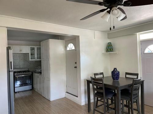 a kitchen with a dining room table and a ceiling fan at Travellers Villa in Roseau