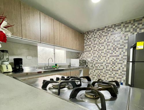 a kitchen with a stove top oven in a kitchen at Vivir La Costa - Casa de Fina in Ríohacha