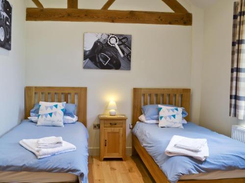 two twin beds in a room with wooden floors at The Apple House in Alderminster