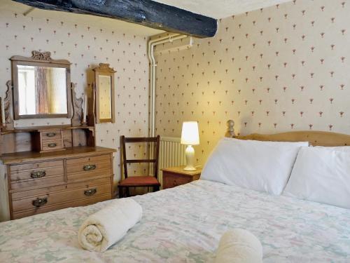 a bedroom with a bed and a dresser and a mirror at Sherrifs Lodge - Hw7730 in Myddfai