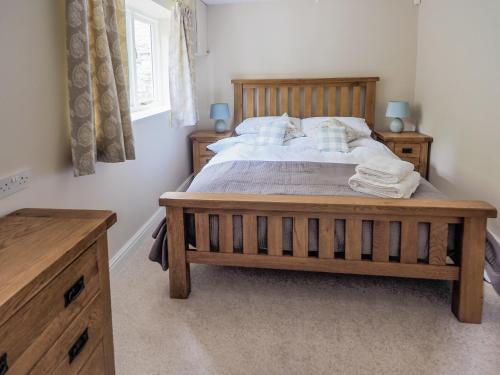 a bedroom with a large wooden bed and a window at Stone Lodge in Fulbeck