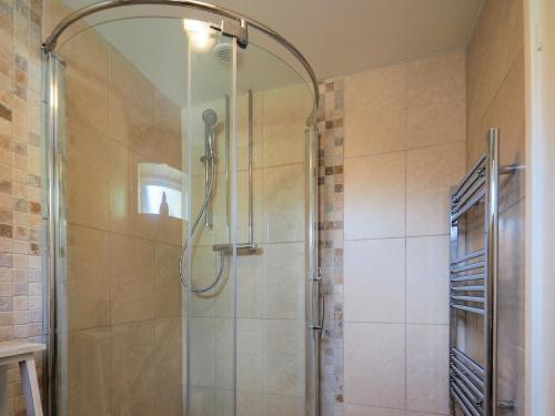 La salle de bains est pourvue d'une douche avec une porte en verre. dans l'établissement Stone Lodge, à Fulbeck