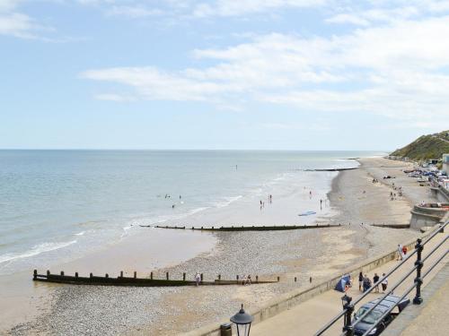 a beach with people on the sand and the ocean at Barley Cottage - W40837 in Horsford