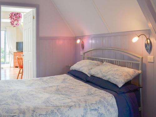 a bedroom with a bed with purple walls at The Summer House in Tintagel