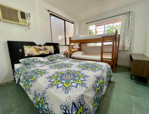 a bedroom with a bed and a bunk bed at Vivir La Costa - Casa de Fina in Ríohacha