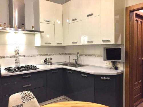 a kitchen with black and white cabinets and a sink at VIP Квартира Подобово Центр, 2 кімнати, Смарт ТВ, Документи in Rivne