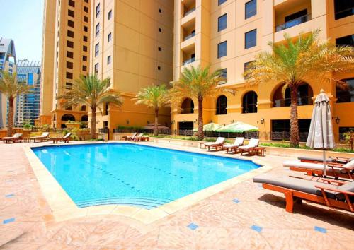 a swimming pool in front of a building at Luxury JBR Shams - Sea or Marina View - Free 5 star Beach Resorts Access! in Dubai