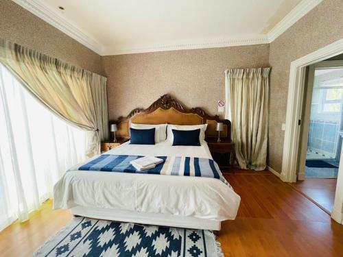 a bedroom with a large bed with blue and white pillows at Nine On Borghorst in Port Elizabeth