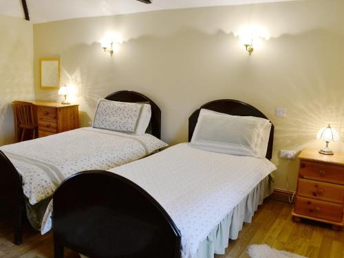two beds in a room with two lights on the wall at Wykham in Nettleton