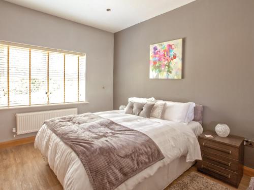 Un dormitorio con una cama grande y una ventana en Three The Old Stables en Knitsley
