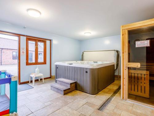 um quarto com uma banheira num quarto em Pantiles Barn - E3866 em Runcton Holme