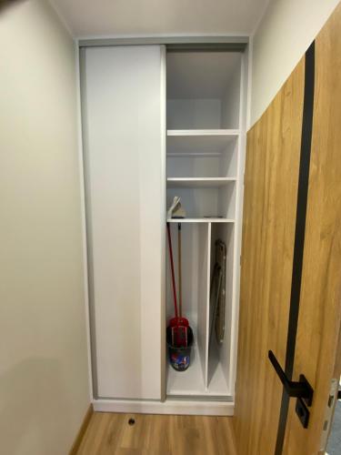 a white cabinet with a red object in it at Apartamenty Białe nad jeziorem Białym in Augustów