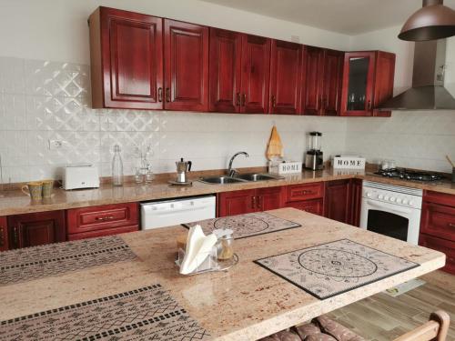 a kitchen with red cabinets and a wooden counter top at The Blue House in Las Lagunas