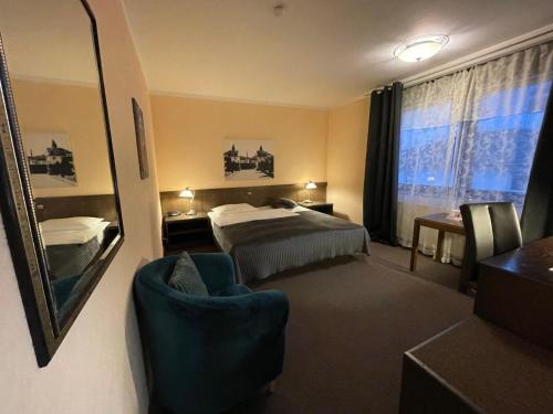 a hotel room with a bed and a chair and a mirror at Hotel Brunnenhof in Bad Nauheim