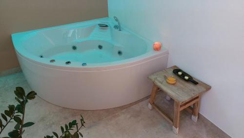 a bath tub in a bathroom with a wooden stool at Over the Castle Apartment in Trento