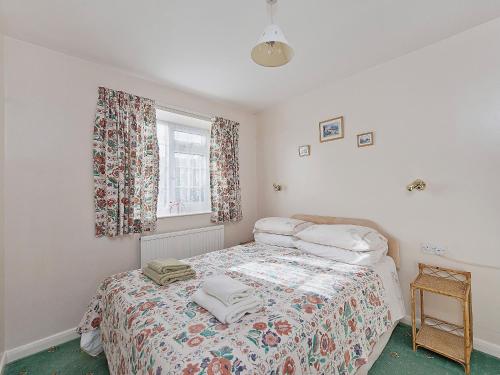 a bedroom with a bed with towels on it at Pear Tree Farm Cottages - Rchm38 in Ebberston