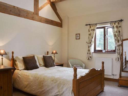 a bedroom with a large bed and a window at Skimblescott Barn in Monkhopton