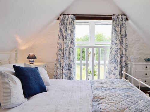 a bedroom with a bed and a large window at Woodside Cottage in Auchnastank
