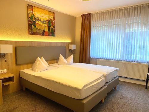 1 dormitorio con 1 cama grande con sábanas blancas en Monteurwohnung en Emstek