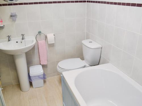 Łazienka z białą toaletą i umywalką w obiekcie Sunrise w Looe