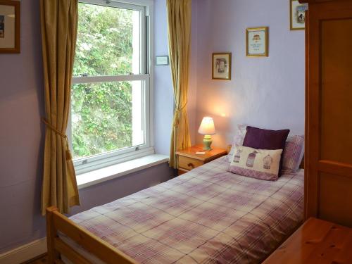 a bedroom with a bed and a window at Sunrise in Looe