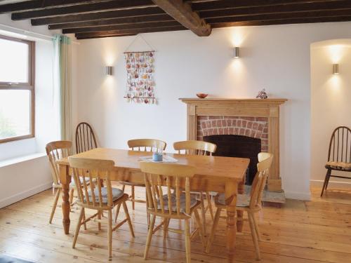 a dining room with a table and chairs and a fireplace at Smugglers Lookout in Mundesley