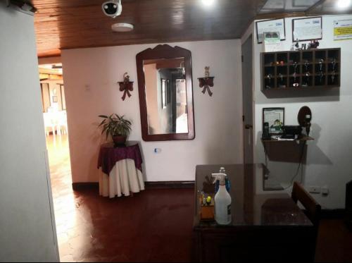 Habitación con encimera, espejo y mesa. en Hotel Don Blas en Popayán