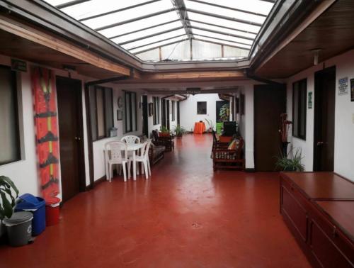 Habitación grande con techo de cristal con sillas y mesas. en Hotel Don Blas, en Popayán