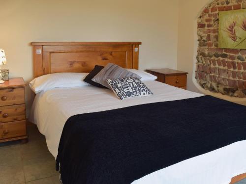 a bedroom with a bed with two pillows on it at Rosemary - E4484a in Ludham