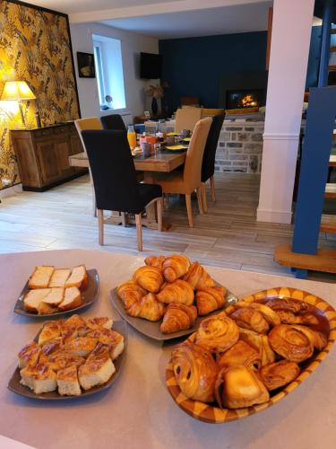 a table with plates of bread and pastries on it at La Maison Keribin in Moëlan-sur-Mer
